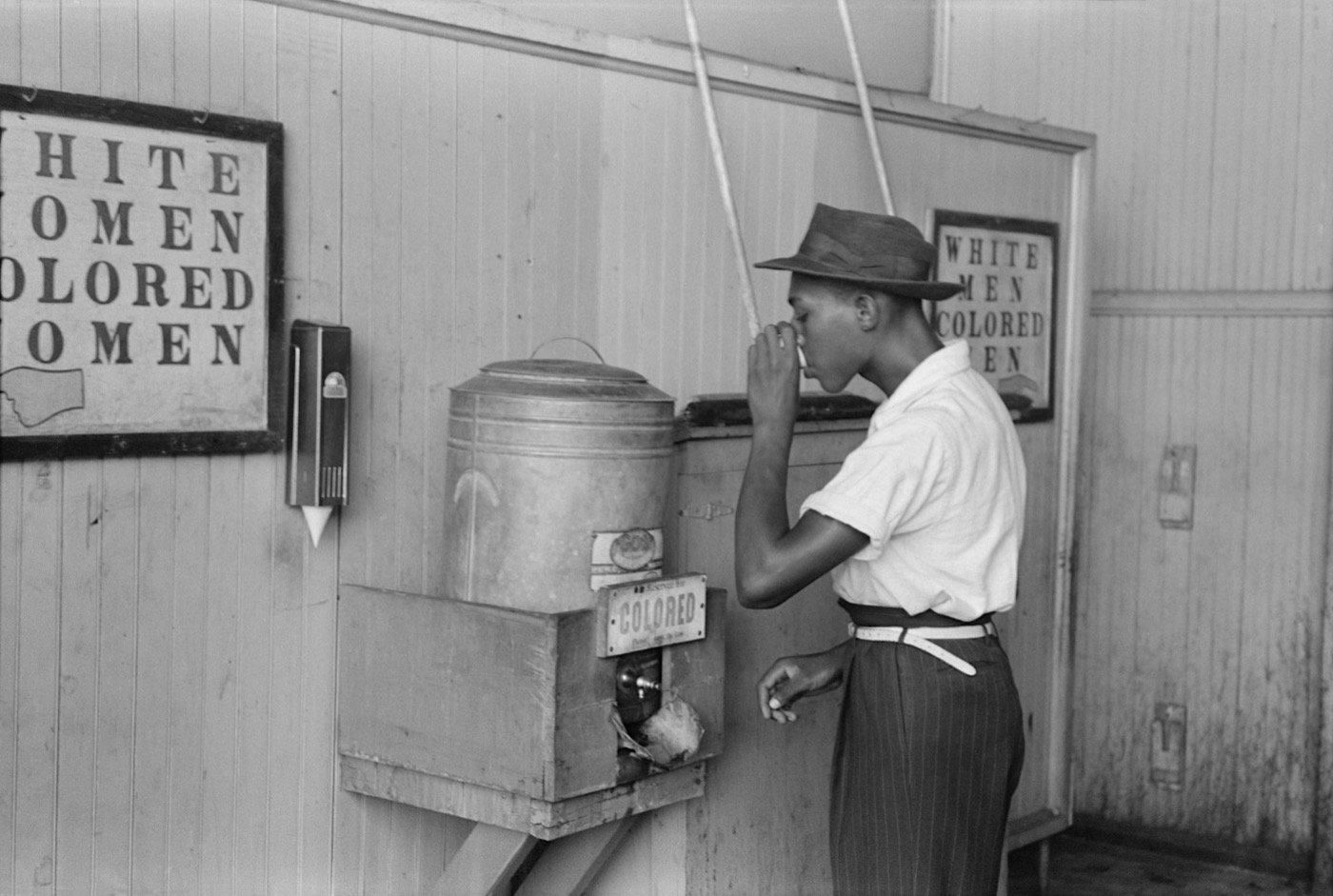 African-American man drinking from a "Colored" water cooler in a streetcar terminal, Oklahoma City, July 1939 (from Wikipedia; photo by Russell Lee)